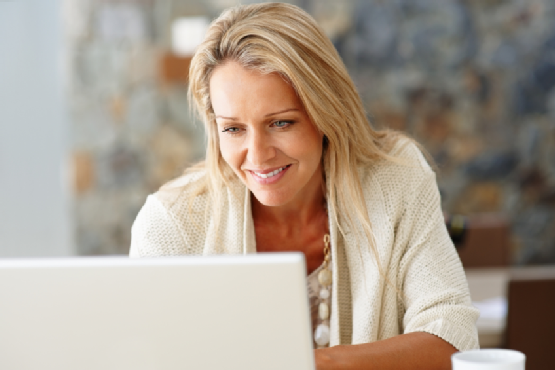 Happy, middle-aged woman using a laptop